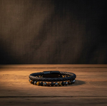 Black leather hematite, tigers eye & black onyx bracelet on a wooden surface
