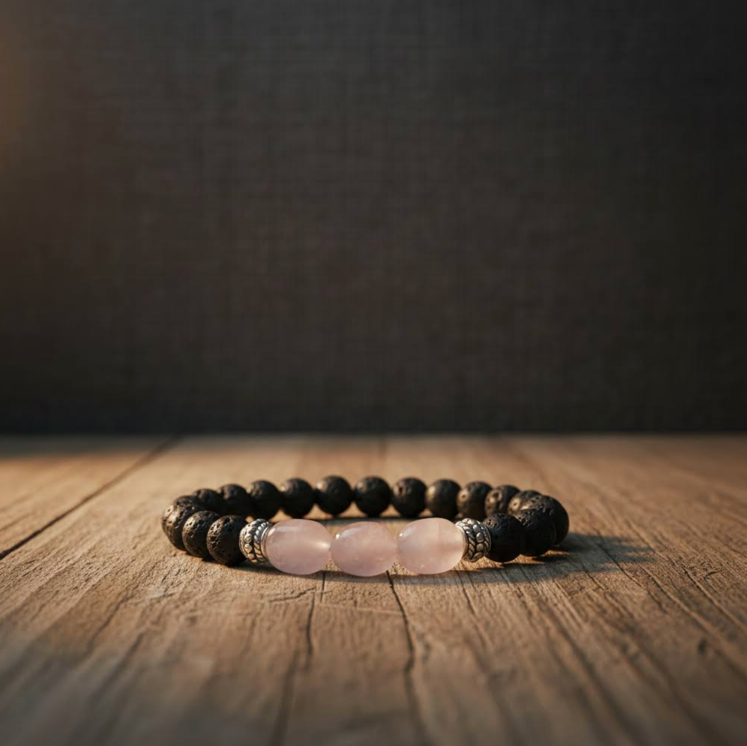 Lava Rock and Rose Quartz Crystal Bracelet on a wooden surface