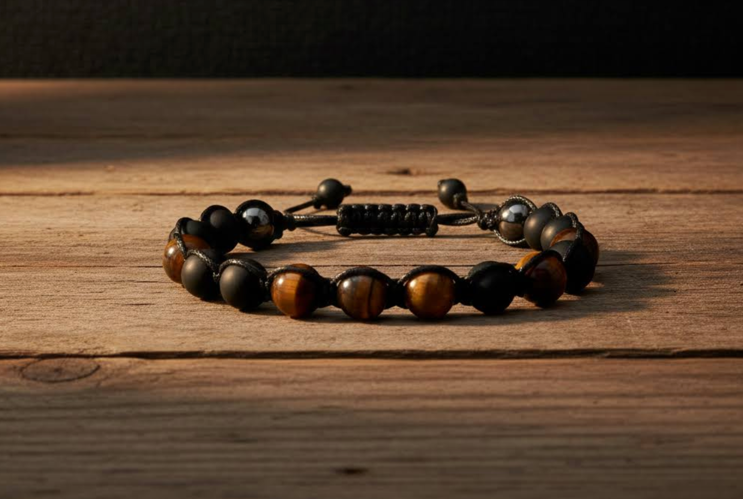 Bracelet with black onyx  and tiger eye  beads on a wooden surface